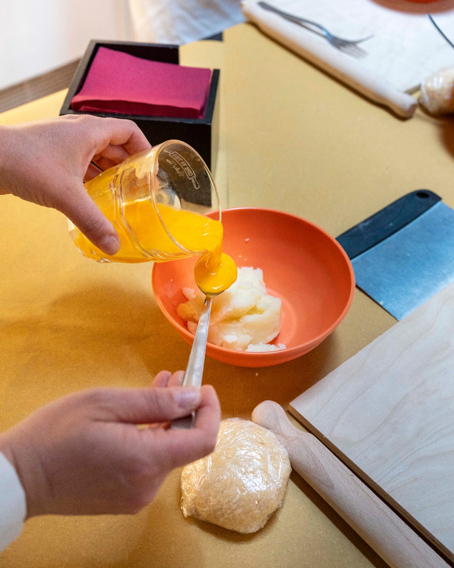 Pouring beaten egg yolk into flour